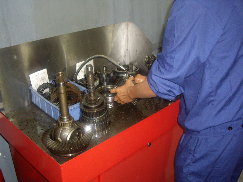 Technician working on transmission internals at the bench