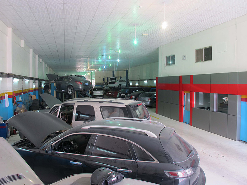 Infiniti FX in foreground with cars on lifts behind